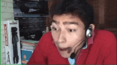 a man wearing a headset is making a funny face while sitting in front of a computer .