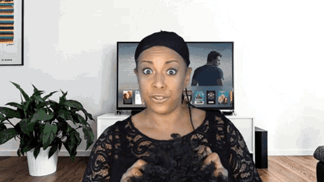 a woman is holding her hair in front of a tv screen that shows a movie called a few weeks ago