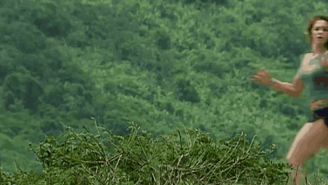 a woman in a tank top and shorts is running through a field .