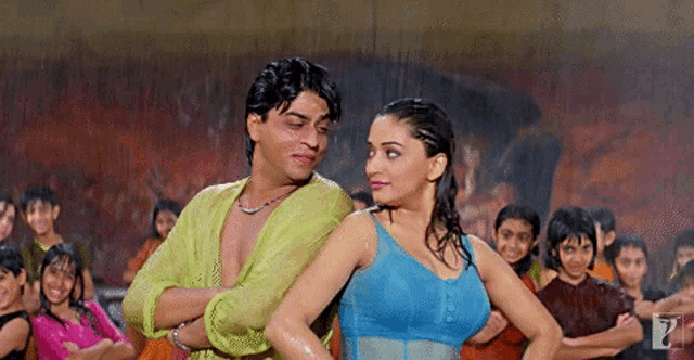 a man and a woman are dancing in the rain and the woman is wearing a blue top