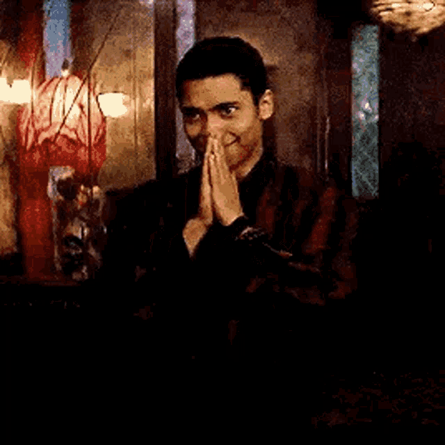 a man is covering his face with his hands in a room .