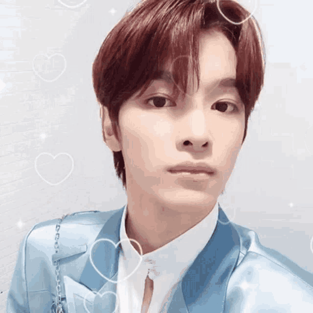 a young man with red hair is wearing a blue suit and white shirt