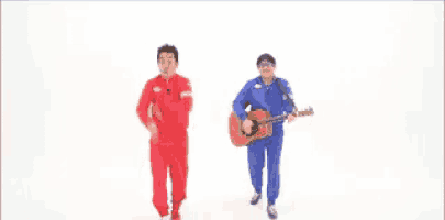 two men are dancing and one of them is playing a guitar .