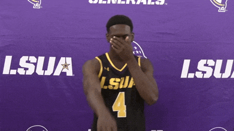 a man in a lsu jersey covers his face