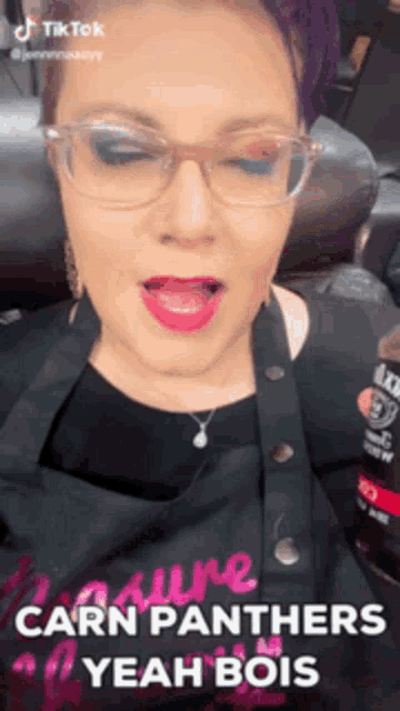 a woman wearing glasses and a black apron says " carn panthers yeah bois "
