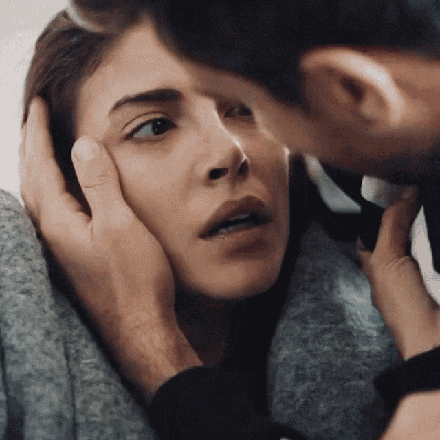 a man kissing a woman 's forehead with his finger