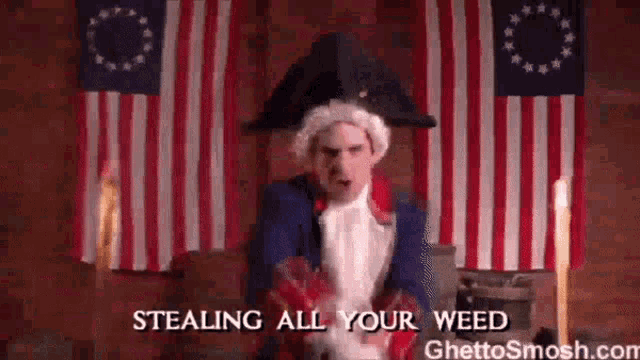 a man in a colonial costume is standing in front of two american flags .