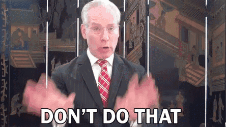 a man in a suit and tie is saying do n't do that with his hands .