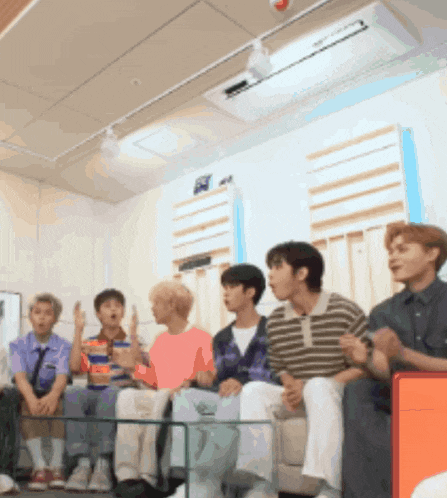 a group of young men sit on a couch in a room