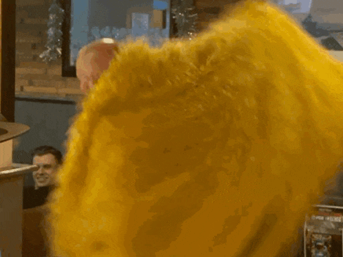 a man in a yellow fur coat is dancing