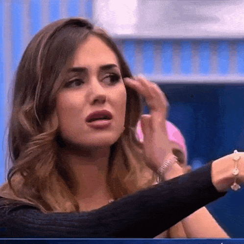 a woman is making a funny face while holding her hand to her face