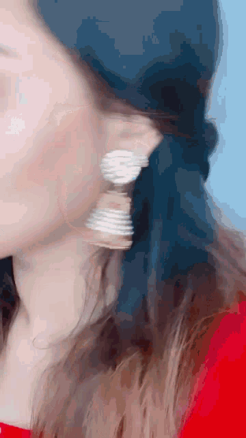 a close up of a woman 's ear with a blue background