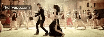 a man and a woman are dancing on a dance floor in front of a crowd .