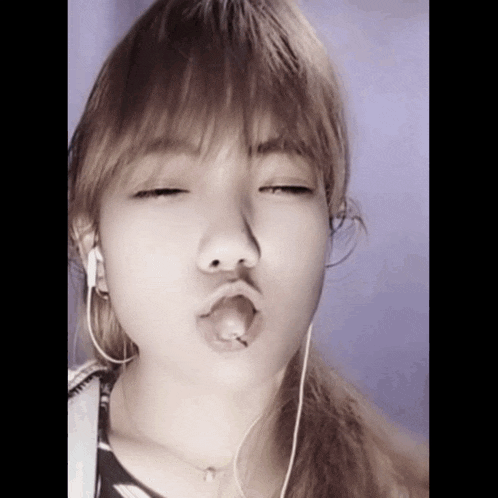 a woman wearing ear buds making a funny face