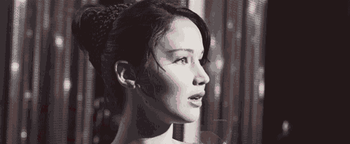 a black and white photo of a woman with a red bow on her shoulder