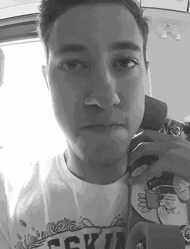 a black and white photo of a man taking a selfie with his phone