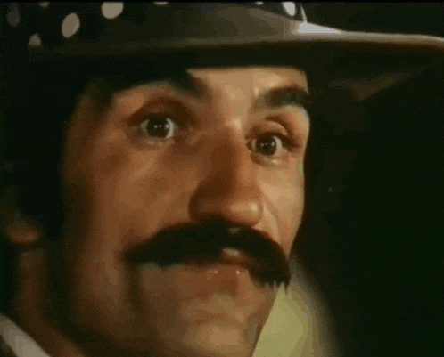 a man with a polka dot hat and a mustache