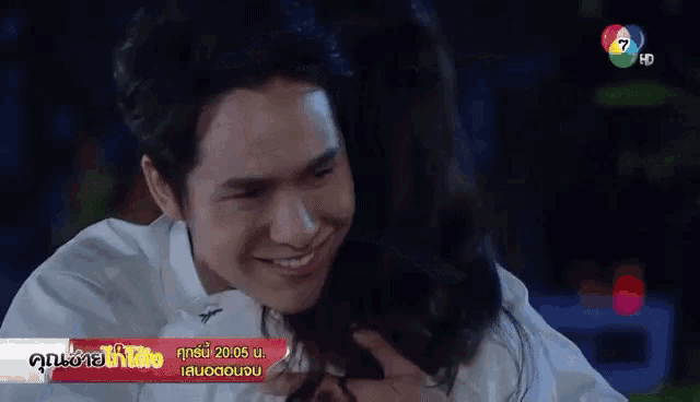 a man and a woman are hugging each other and the man is smiling and the woman is smiling .