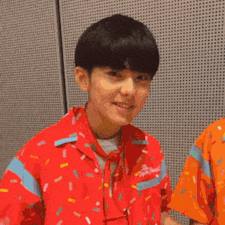 a couple of young men are standing next to each other and smiling .