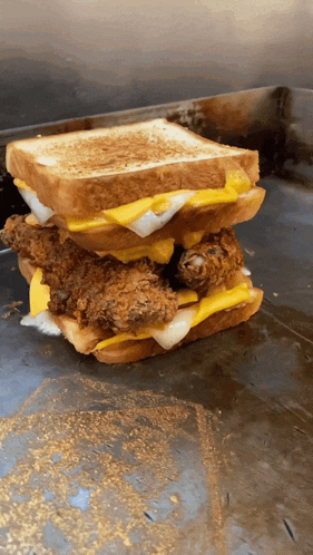 a chicken and cheese sandwich is stacked on top of another sandwich