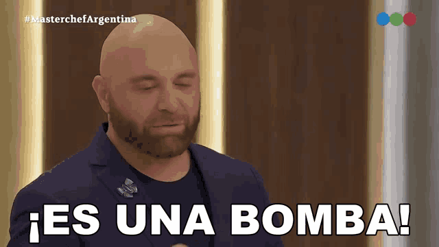 a bald man with a beard says " es una bomba " in white letters