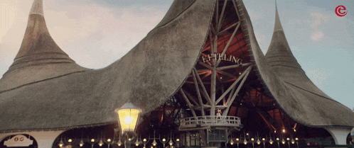 a building with a thatched roof has the word telling on the front