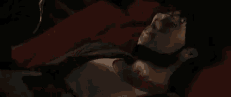 a close up of a woman 's face in a dark room with her eyes closed .