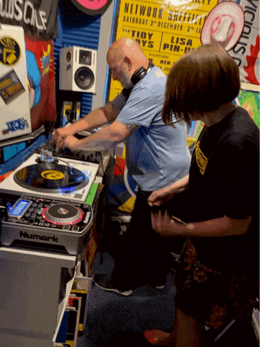 a man playing a record in front of a sign that says network