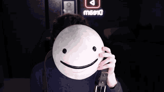 a person holding a mask in front of their face with a sign in the background that says missio
