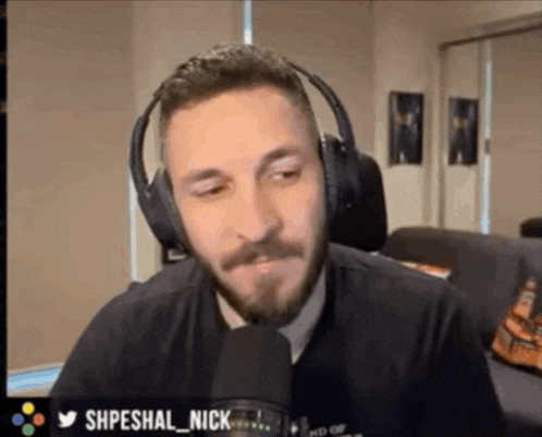 a man with a beard wearing headphones and a microphone with the name shpeshal nick on the bottom