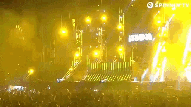 a crowd of people at a concert with a sign that says spinning tv on it
