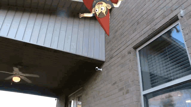 a cartoon character is flying through the air on the side of a brick building