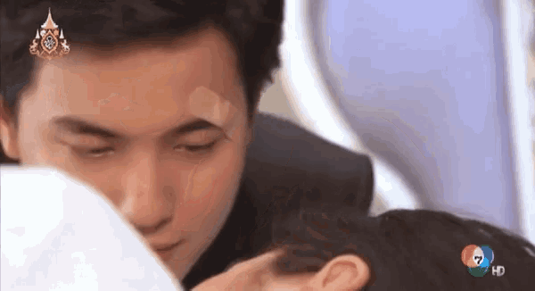a man with a bandage on his forehead is kissing a woman 's forehead
