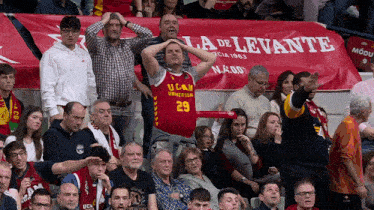 a man wearing a jersey that says 29 stands in front of a banner that says la de levante