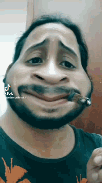 a man with a beard is smoking a cigarette and making a funny face on tik tok