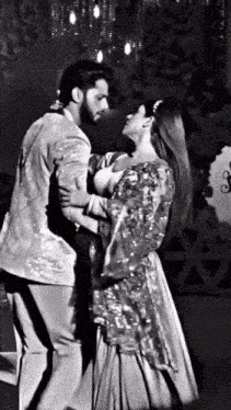 a black and white photo of a man and woman dancing together