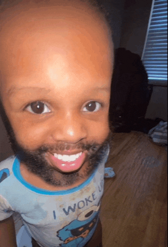 a little boy with a beard and a cookie monster shirt that says i woke up