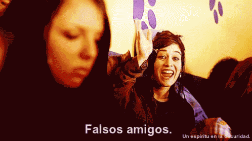 a woman says " falsos amigos " while another woman laughs in the background