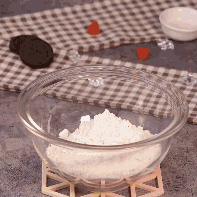 a glass bowl of flour sits on a table