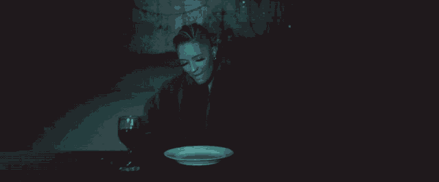 a woman sitting at a table with a glass of wine and a plate