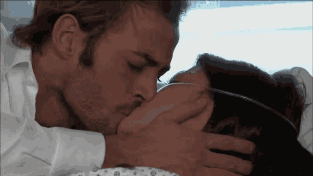 a man is kissing a woman who is wearing an oxygen mask on her face