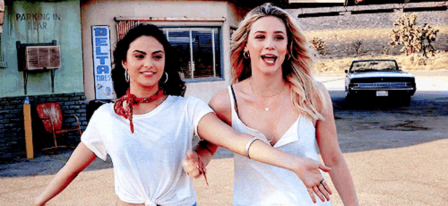two women are walking in front of a building that says delta