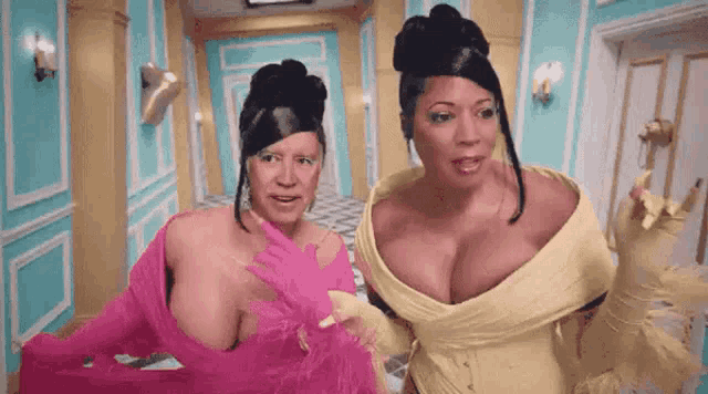 two women are standing next to each other in a hallway .