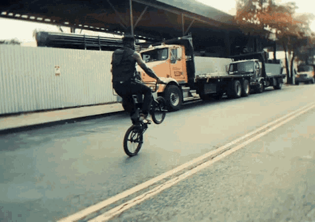 a man is doing a trick on a bike in front of a truck that says ' ecm ' on it