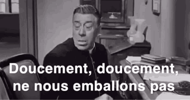 a black and white photo of a priest sitting at a desk with the words " doucement doucement ne nous emballons pas " written below him