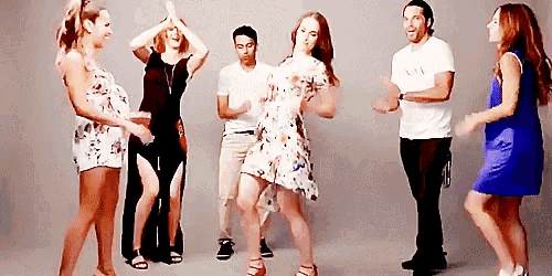 a group of people are dancing together and one of them is wearing a white t-shirt that says armani
