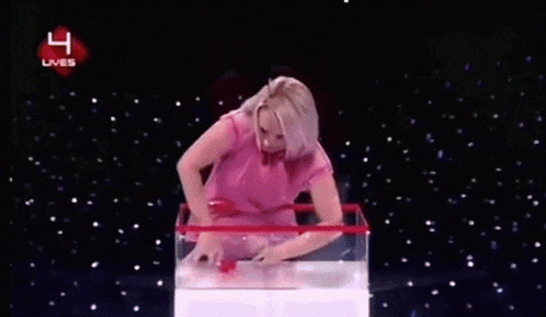 a woman in a pink shirt is standing in front of a box that has the number 4 on it