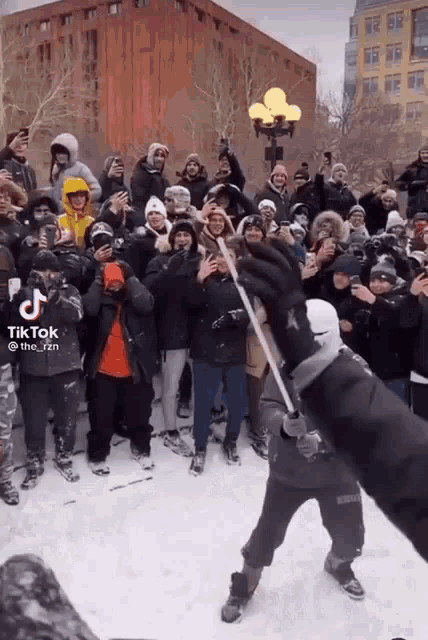 a group of people are gathered in the snow and a tik tok video is being shared