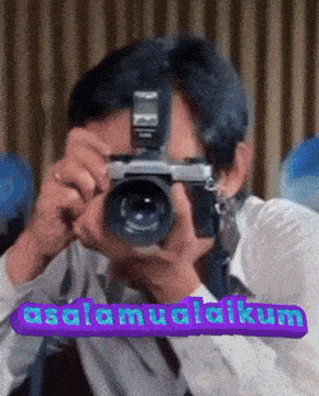 a man is taking a picture with a camera and the words " assalamualaikum " on the bottom right