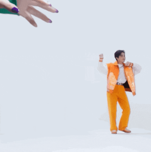 a man in orange pants and an orange jacket is dancing